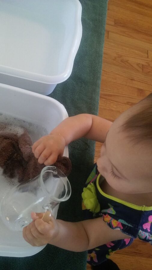 18 month old Montessori Toddler washing pitcher.