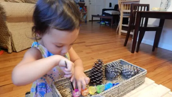 Child painting pinecones