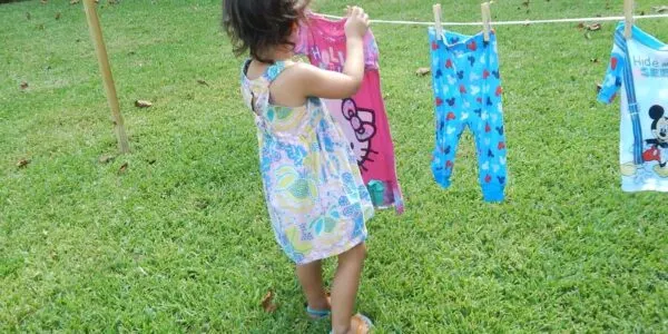toddler hanging clothes on a line as a Practical Life activity