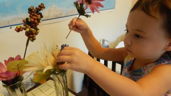 2 year old girl arranging flowers.