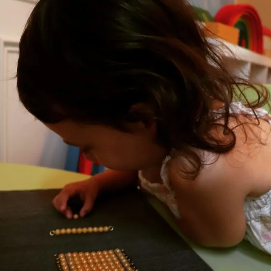 child working with the Golden Bead Material
