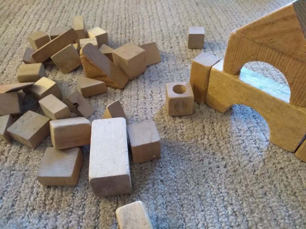 wooden blocks on floor, Montessori: Expectation vs. Reality.