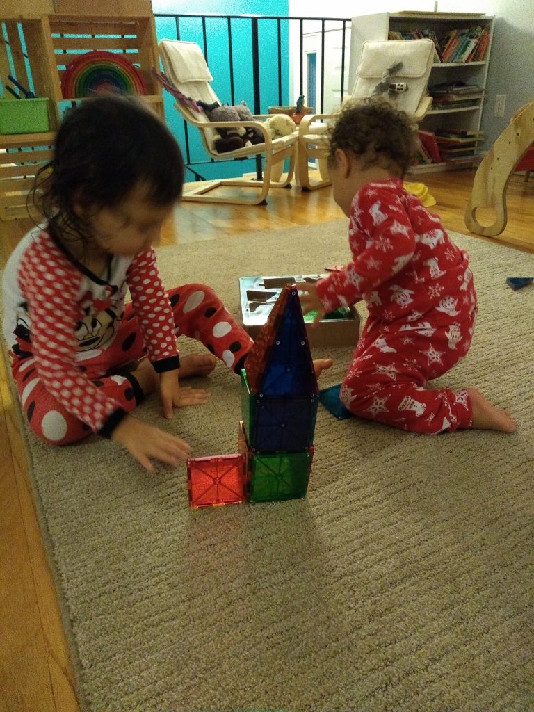 two children building with magna-tiles, great pre- Montessori math and common core skills.