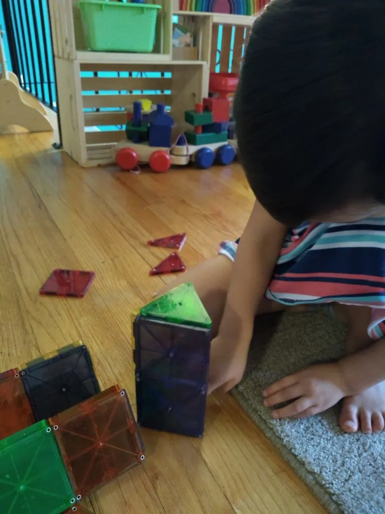 child playing with Magna-tiles, a great Montessori aligned gift.