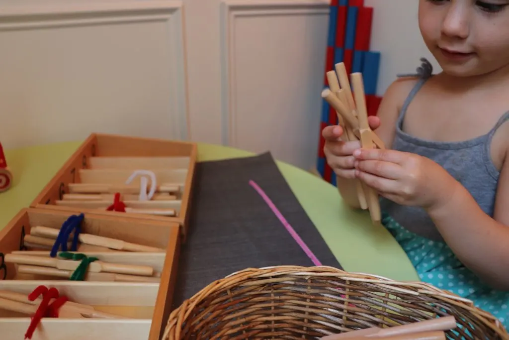 Child counting Montessori Wooden Spindles to be placed in spindle boxes.