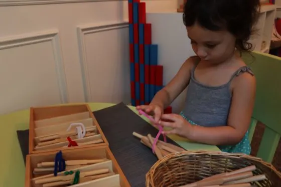 young girl working with the Montessori Spindle Boxes