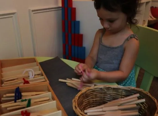 child using Montessori spindle boxes.