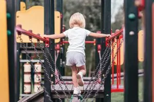 A preschool aged child on a play gym, experiencing the importance of free play