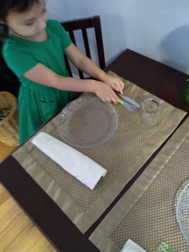 child setting a table.