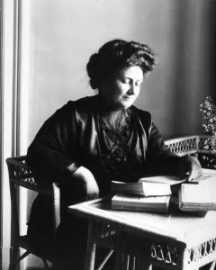Maria Montessori Facts: black and white photo of Maria Montessori at a desk.