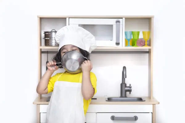 child with ikea Montessori play kitchen.