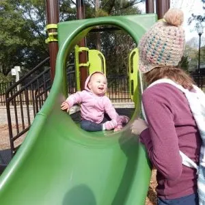 toddler on slide proud of herself. An example of why good job is harmful