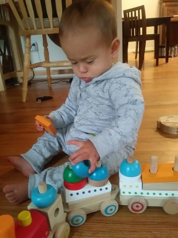 baby playing with wooden train