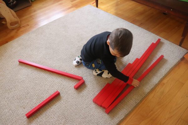 Child working with the Montessori Red Rods.