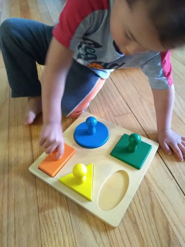 Toddler playing with knobbed puzzle