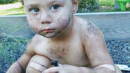 Young toddler engaging in messy play in the garden.