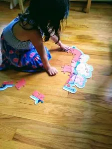 4 year old putting puzzle together. Puzzles are good for you and great STEM toys..