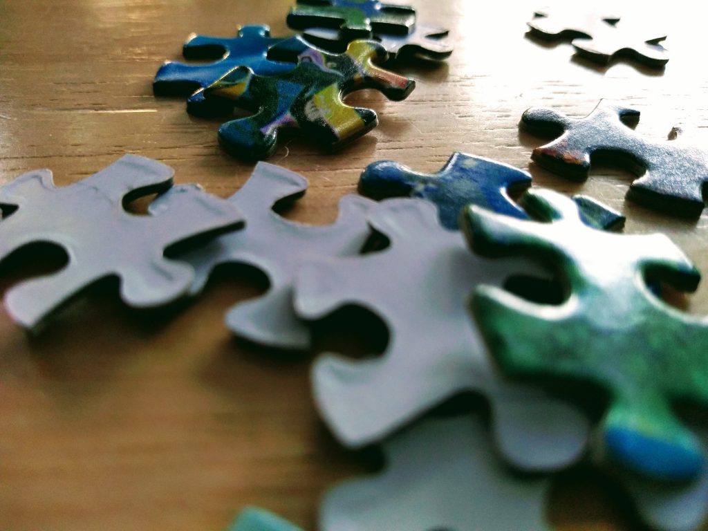 "Why puzzles are good for you" image of puzzle pieces on table.