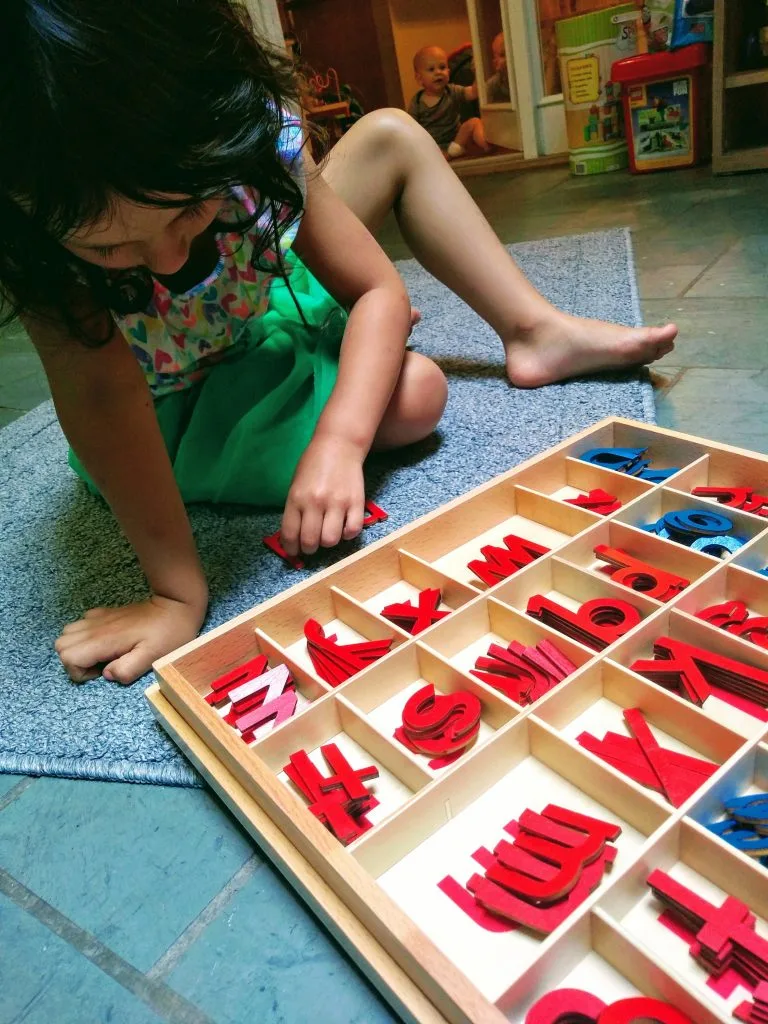 child working with the small movable alphabet in Montessori.