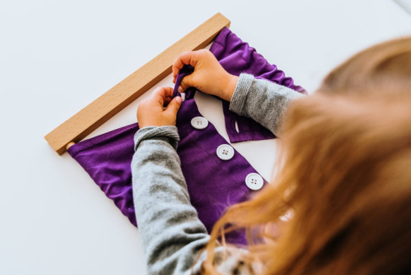 Child using Montessori Button Frame