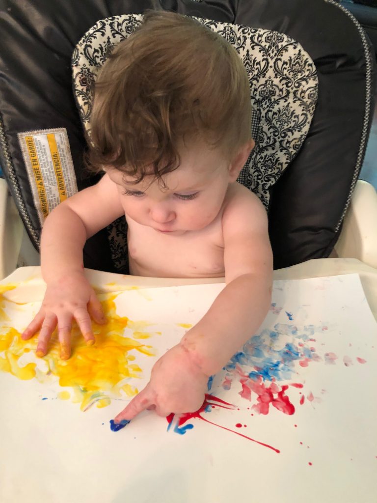 baby fingerpainting to improve fine motor skills.