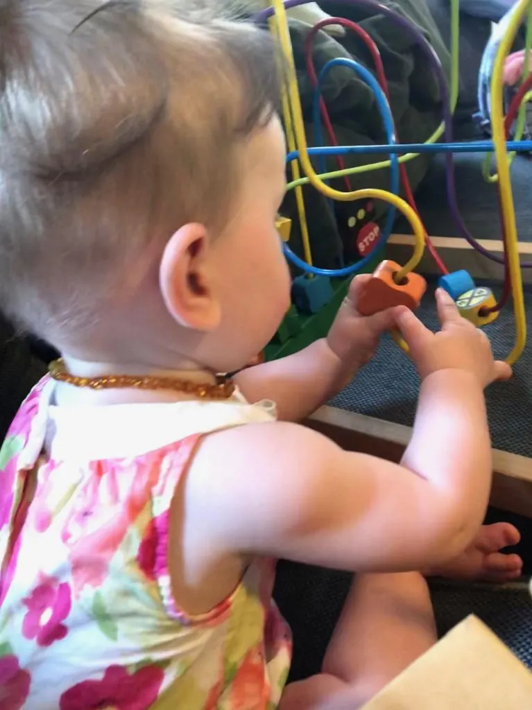 baby playing with bead maze