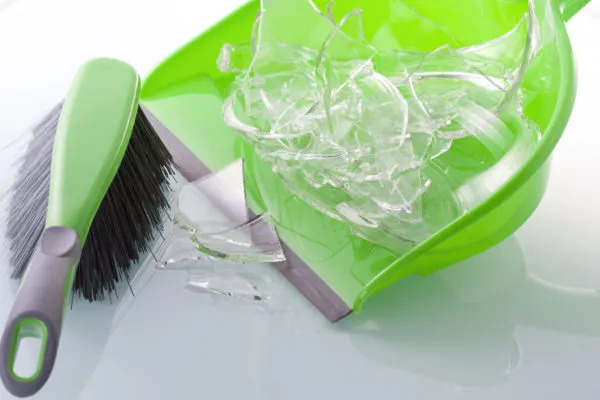 dustpan with broken glass, cleaning up their mess is an example of natural consequences.