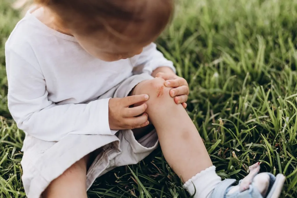 A child with a scrape on her knee. A natural consequence of running.