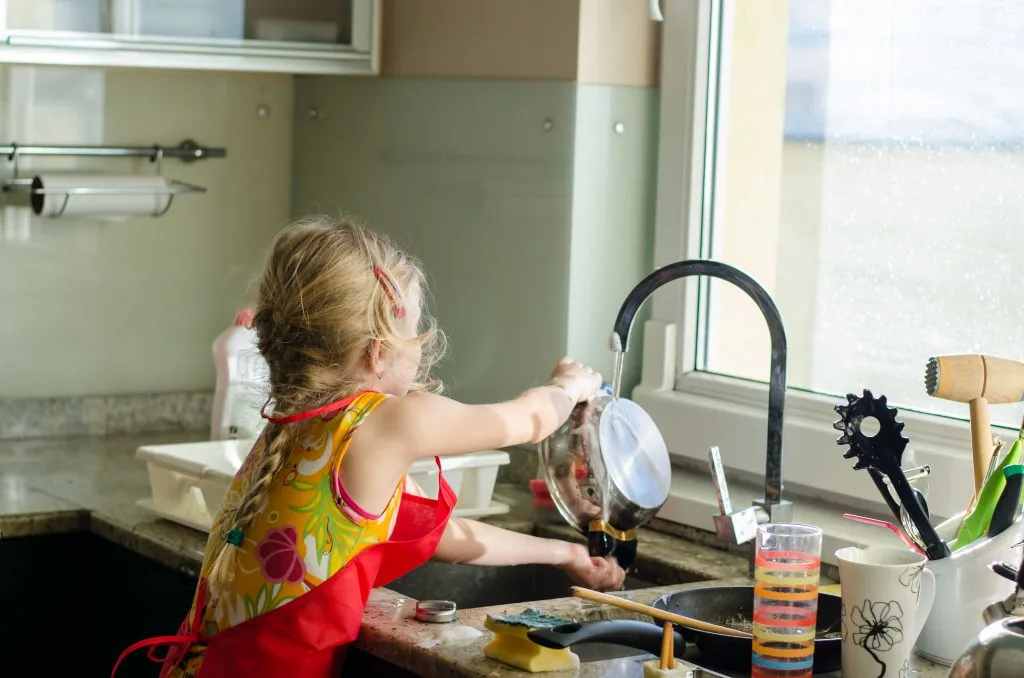 child washing dishes