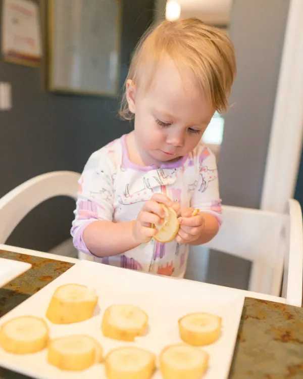 Toddler peeling fruit