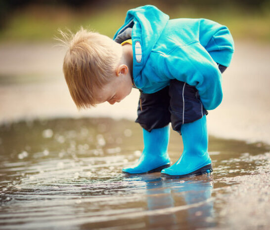 a boy using his Absorbent Mind, exploring a puddle, during a sub- plane of development.