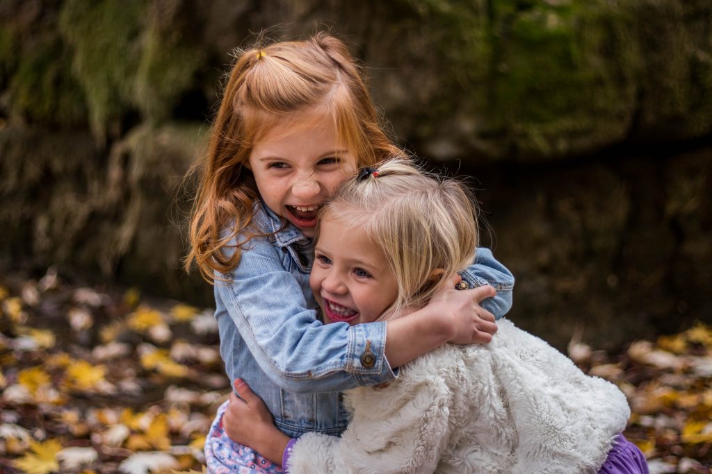 two girls hugging, showing emotional intelligence.
