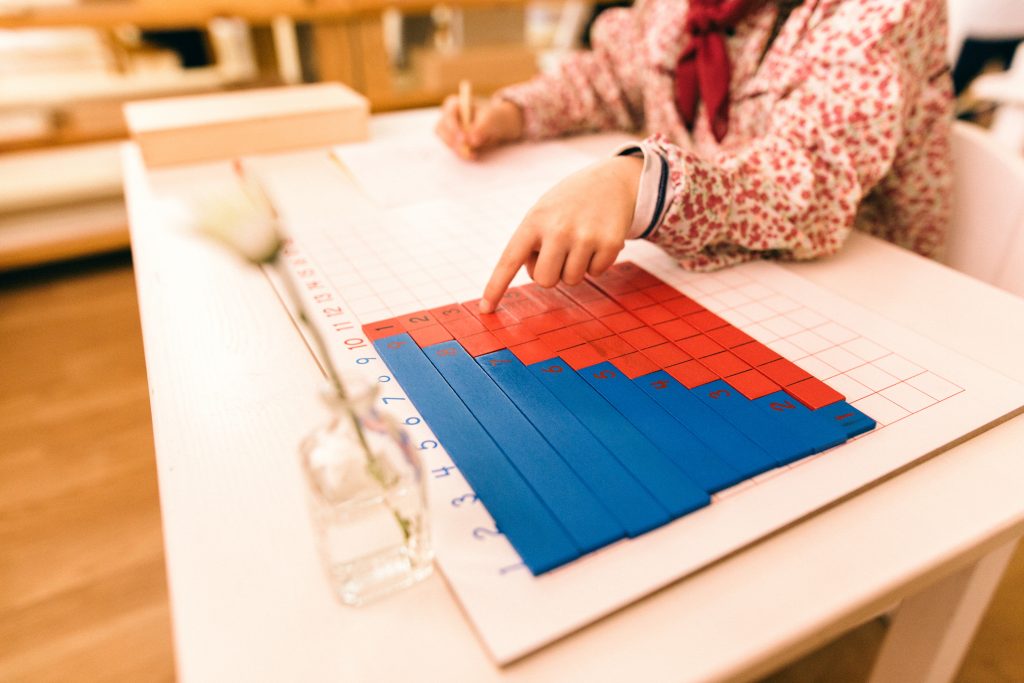 Child working with Montessori Materials. Young children working with advanced material is a common Montessori criticism.