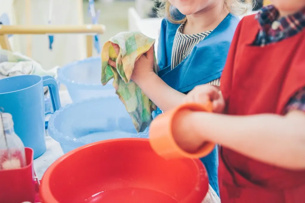 Children washing dishes. A common Montessori criticism.
