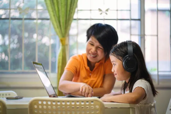 Mother helping her child with online learning