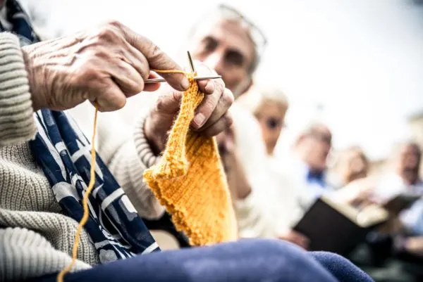 Montessori in Nursing Homes, an older person knitting, a fine motor skill activity.