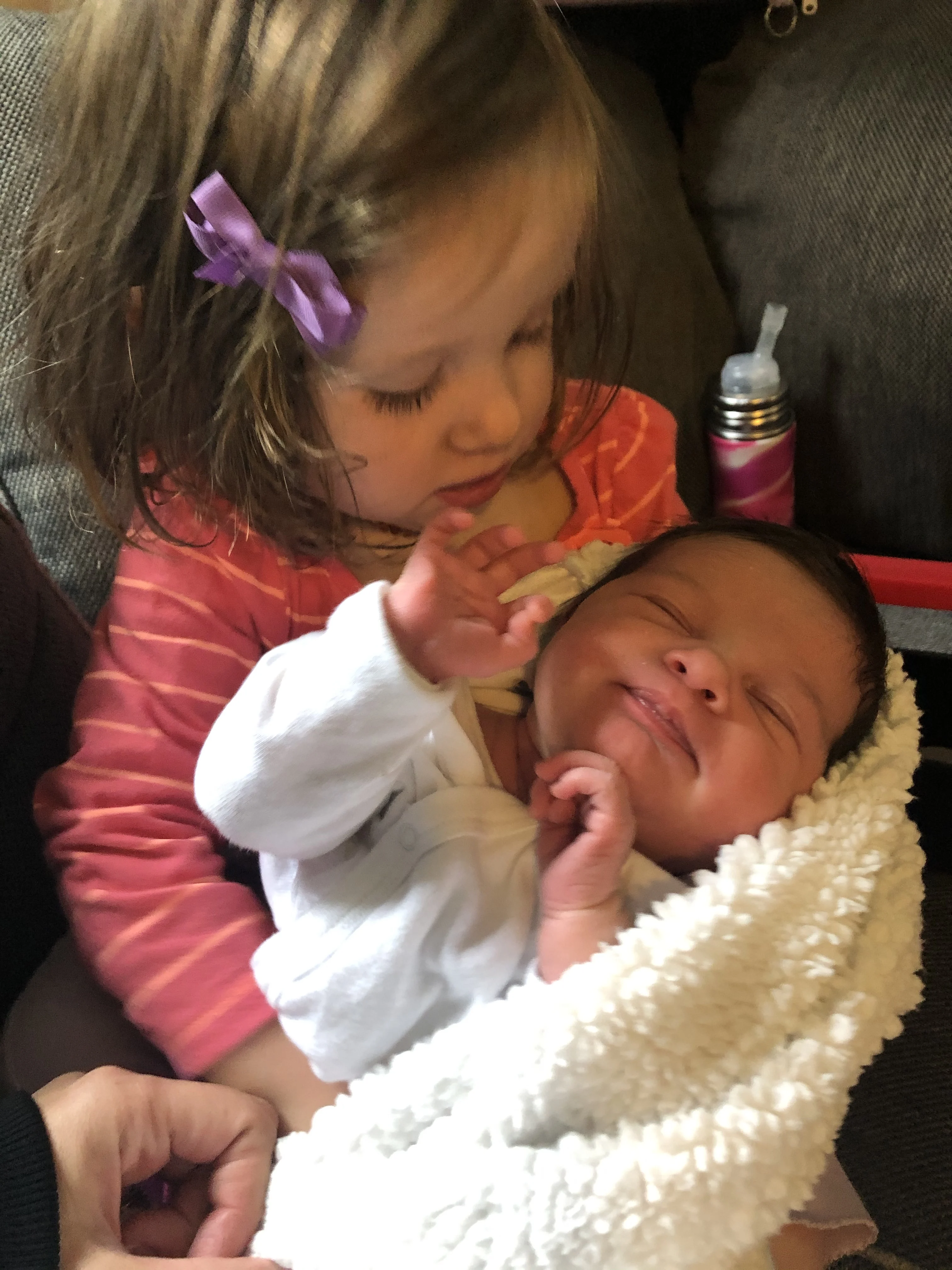 toddler holding new baby