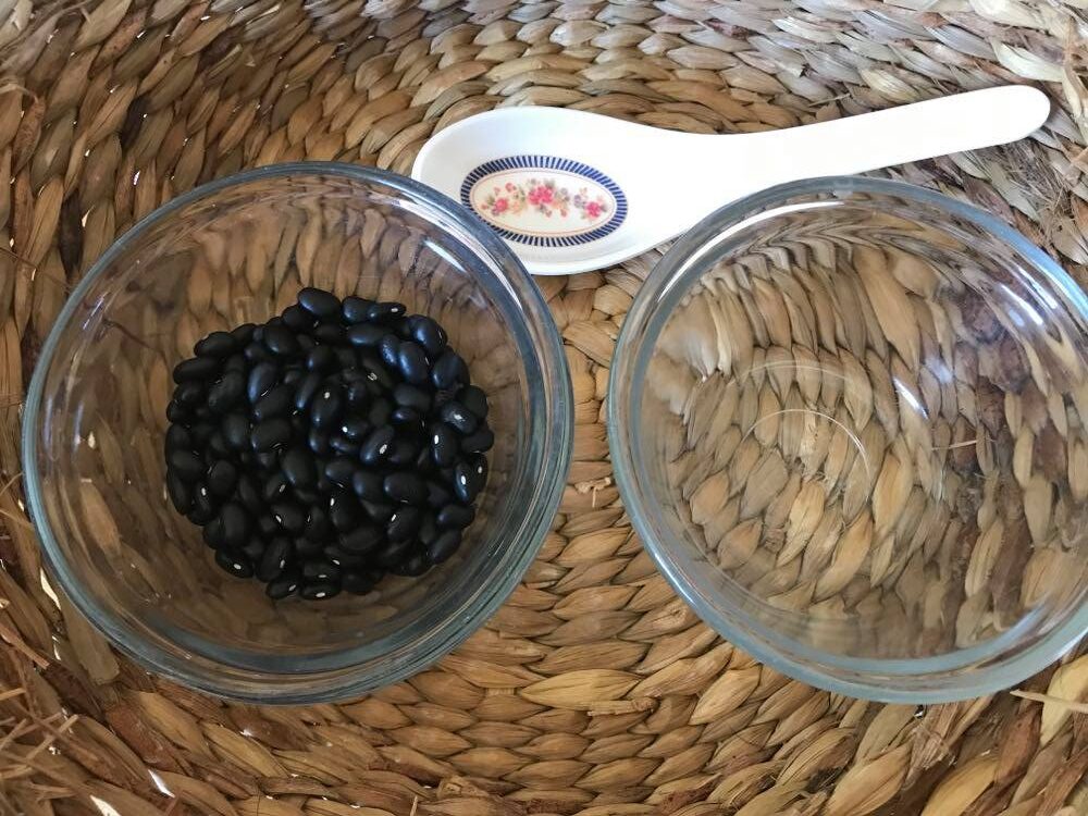 Beans, bowls, and spoon in a basket for Montessori spooning activities.