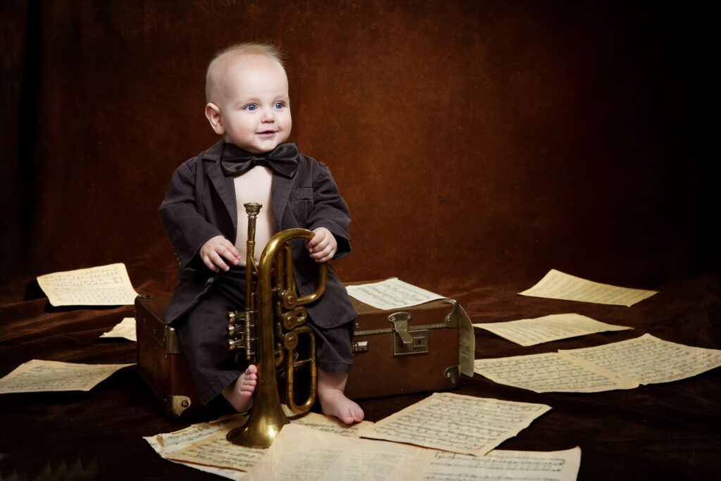 child sitting with horn and music.