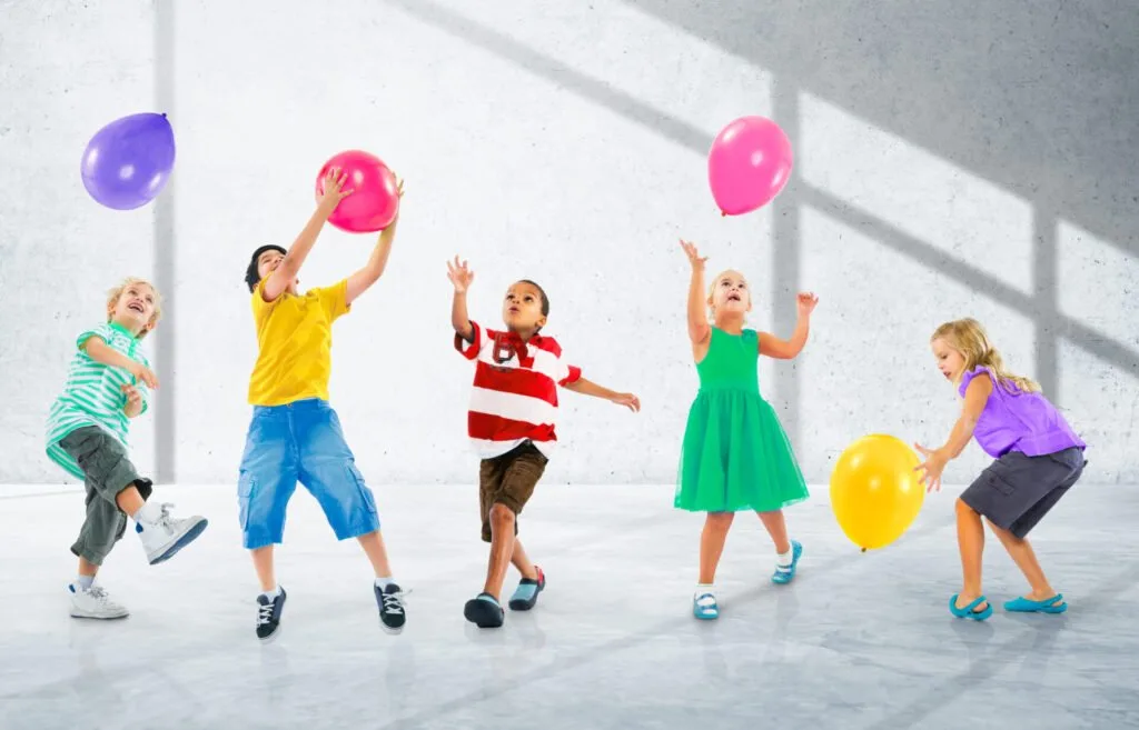 kids moving to the music and playing with balloons.