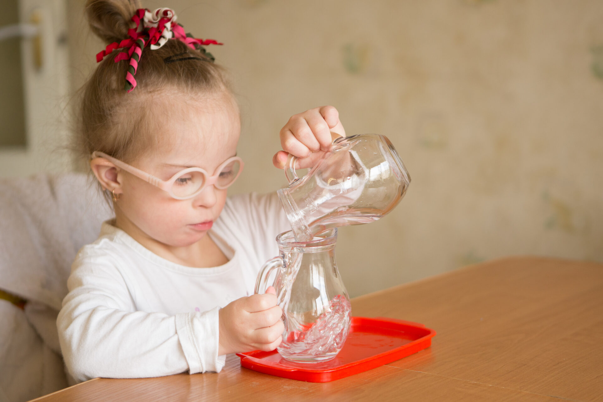 child doing montessori water pouring activity.