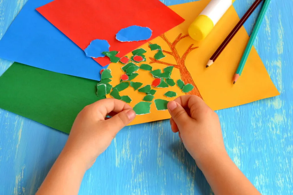 child tearing paper for montessori paper tearing activity.