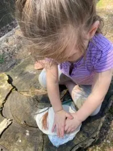 toddler pressing nature materials in air dry clay.