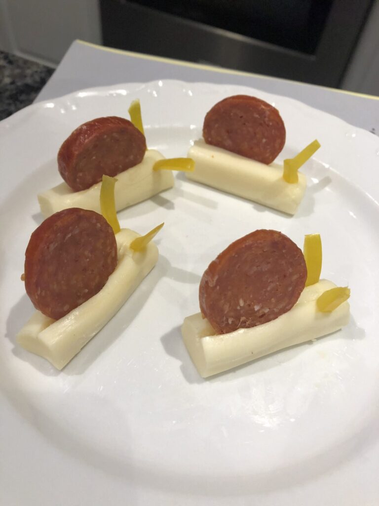 Snails made from mozzarella sticks, pepperoni and yellow pepper antennas.