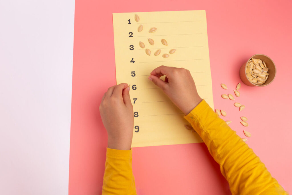 child using sunflower seeds for math activity.