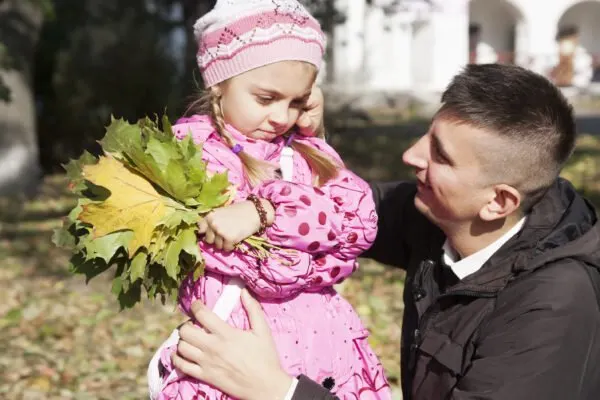 father showinf posisitve discipline to child holding flowers.