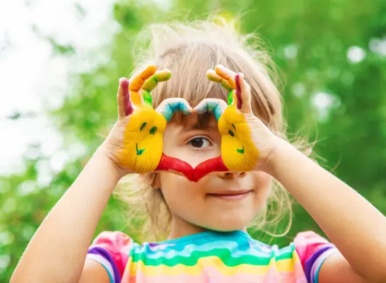 image of child making heart with hands with items from Montessori subscription boxes.