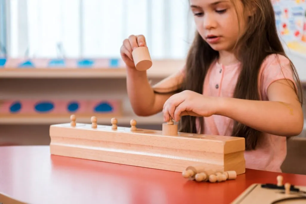 image of girl using montessori knobbed cylinders.