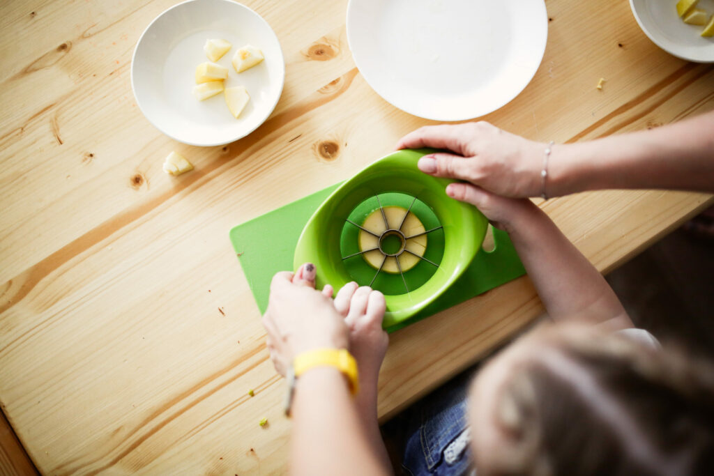 image of child cutting an apple when doing Montessori at home.