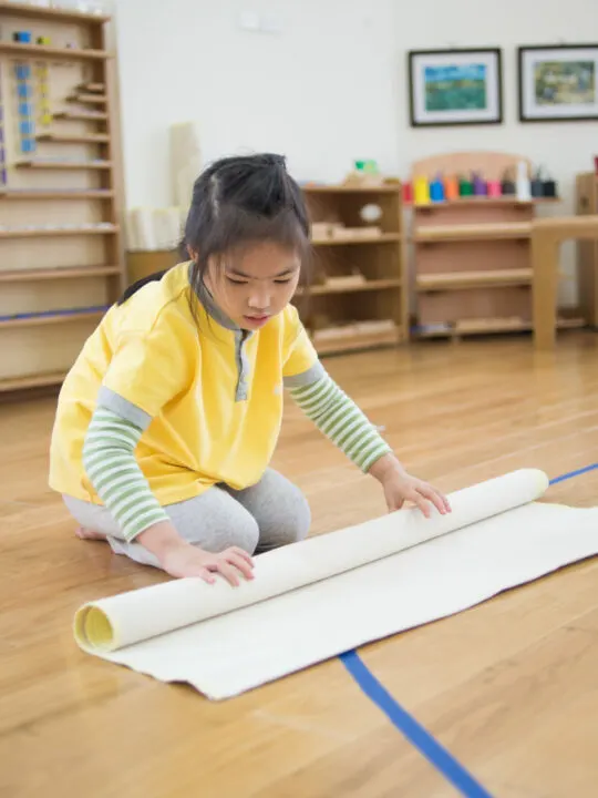 image of child in Montessori classroom to prepare for a Montessori work cycle.